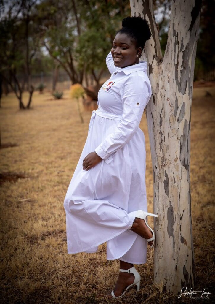 An african women in a white dresses with an afro
