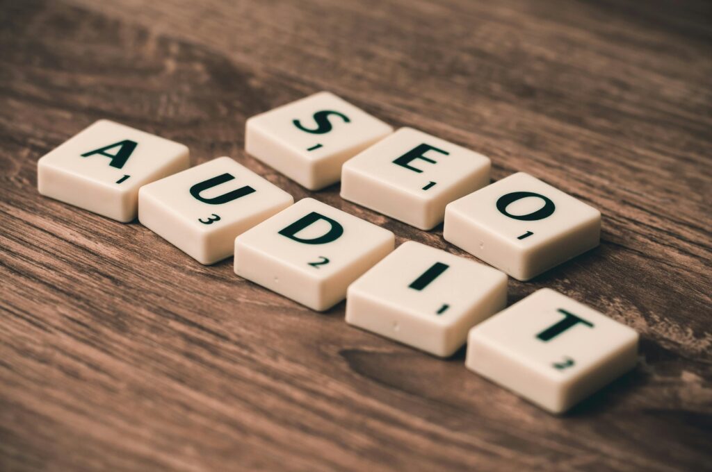 SEO Audit in digital Marketing Scrabble tiles spelling SEO Audit on wooden surface, symbolizing digital marketing strategies.