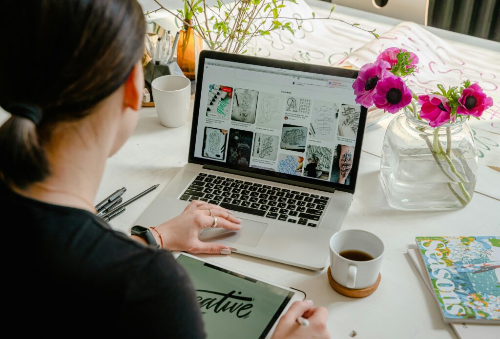 Creativity Woman in a creative workspace using a laptop and tablet for calligraphy. Artistic and tech-driven environment. Showing how we craft our digital marketing stratergies